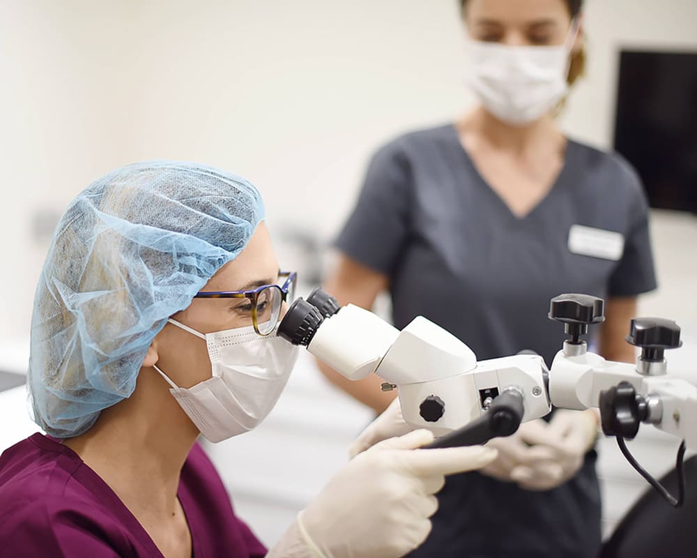 Doctora-Observando-microscopio-Medic-Dental-Sabadell-min2